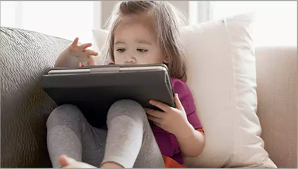 Little girl playing on an iPad Link