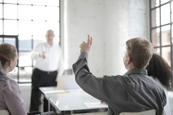 An employee raising his hand to ask a question
